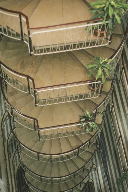 Free Top view of a spiral staircase adorned with plants, offering a unique architectural perspective. Stock Photo
