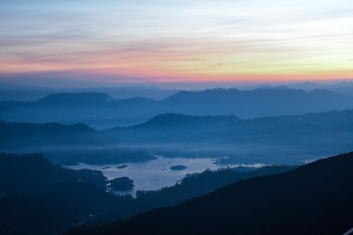 Free A tranquil mountainous scene with a lake at sunset, capturing serene and peaceful beauty. Stock Photo