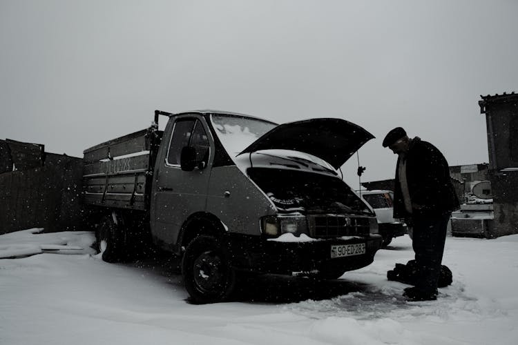 Man Looking Under The Hood Of A Truck 