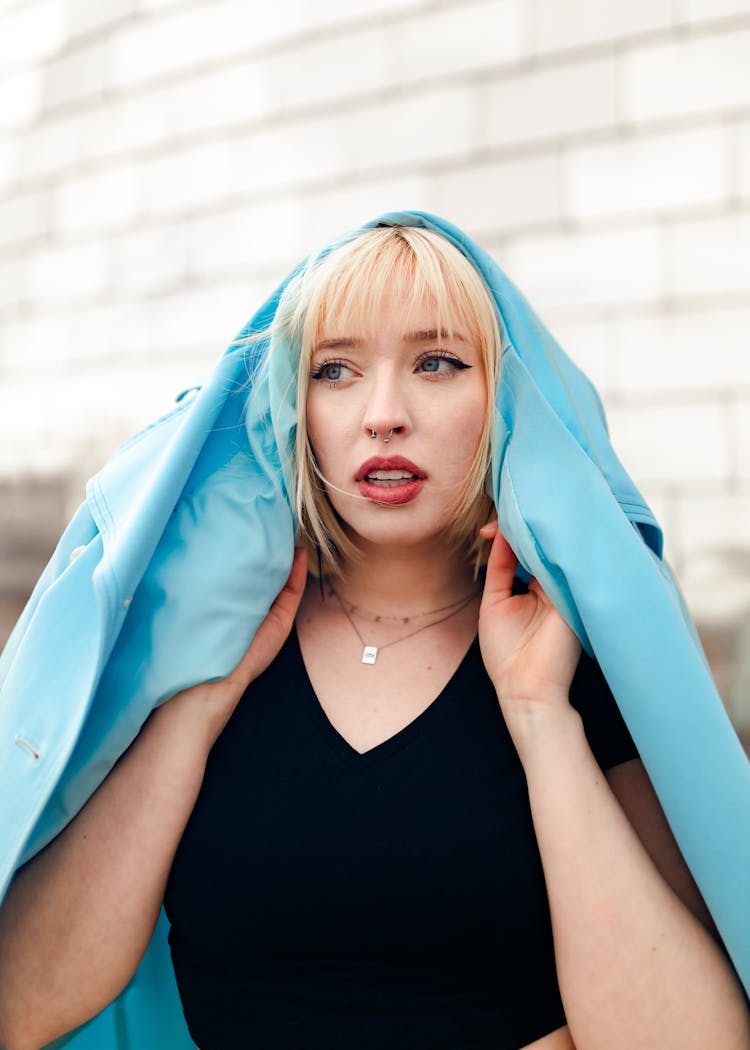 Portrait Of Woman Holding Jacket Over Head