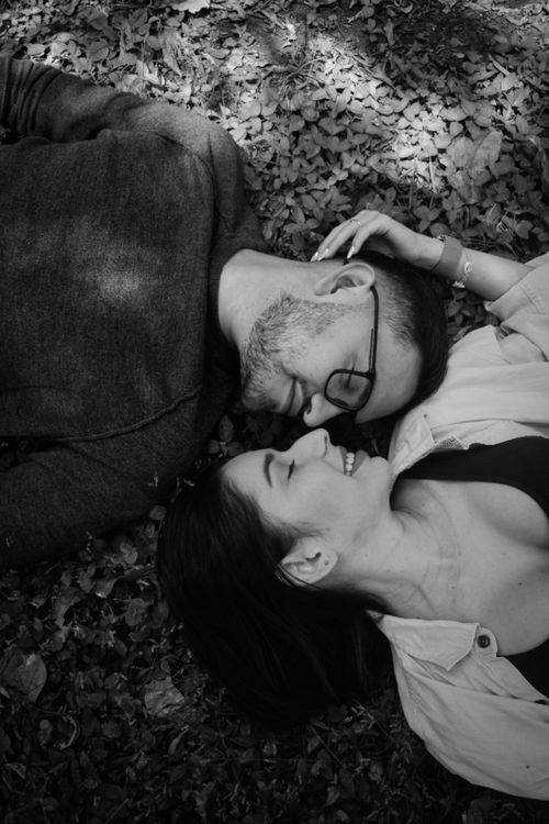 Free A romantic black and white portrait of a couple lying on the ground sharing a happy moment. Stock Photo