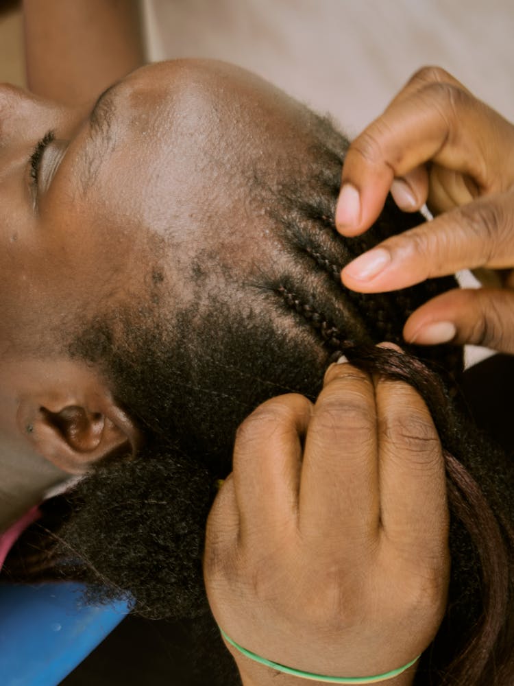 A Young Woman Having Her Hair Braided