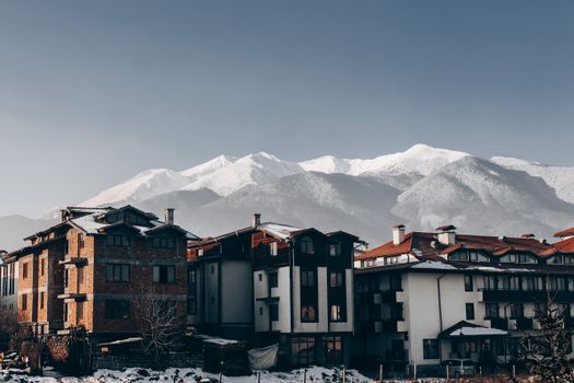 Snow-covered buildings in Bansko with majestic mountain backdrop, perfect for winter travel inspiration. 15576694