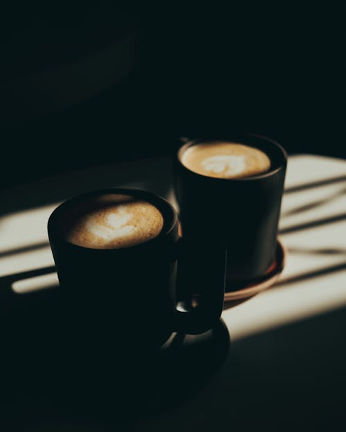 Mugs with Coffee Standing in Sunlight 