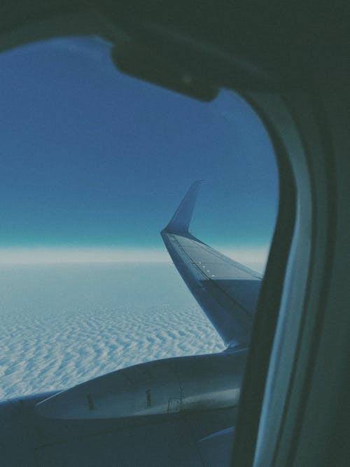 View of White Clouds and Blue Sky from an Airplane Window 