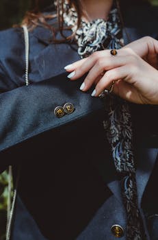 Detailed close-up of a woman showcasing elegant fashion with a blazer and patterned scarf.