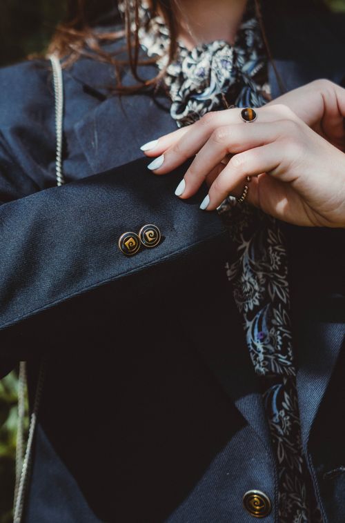 Free Detailed close-up of a woman showcasing elegant fashion with a blazer and patterned scarf. Stock Photo