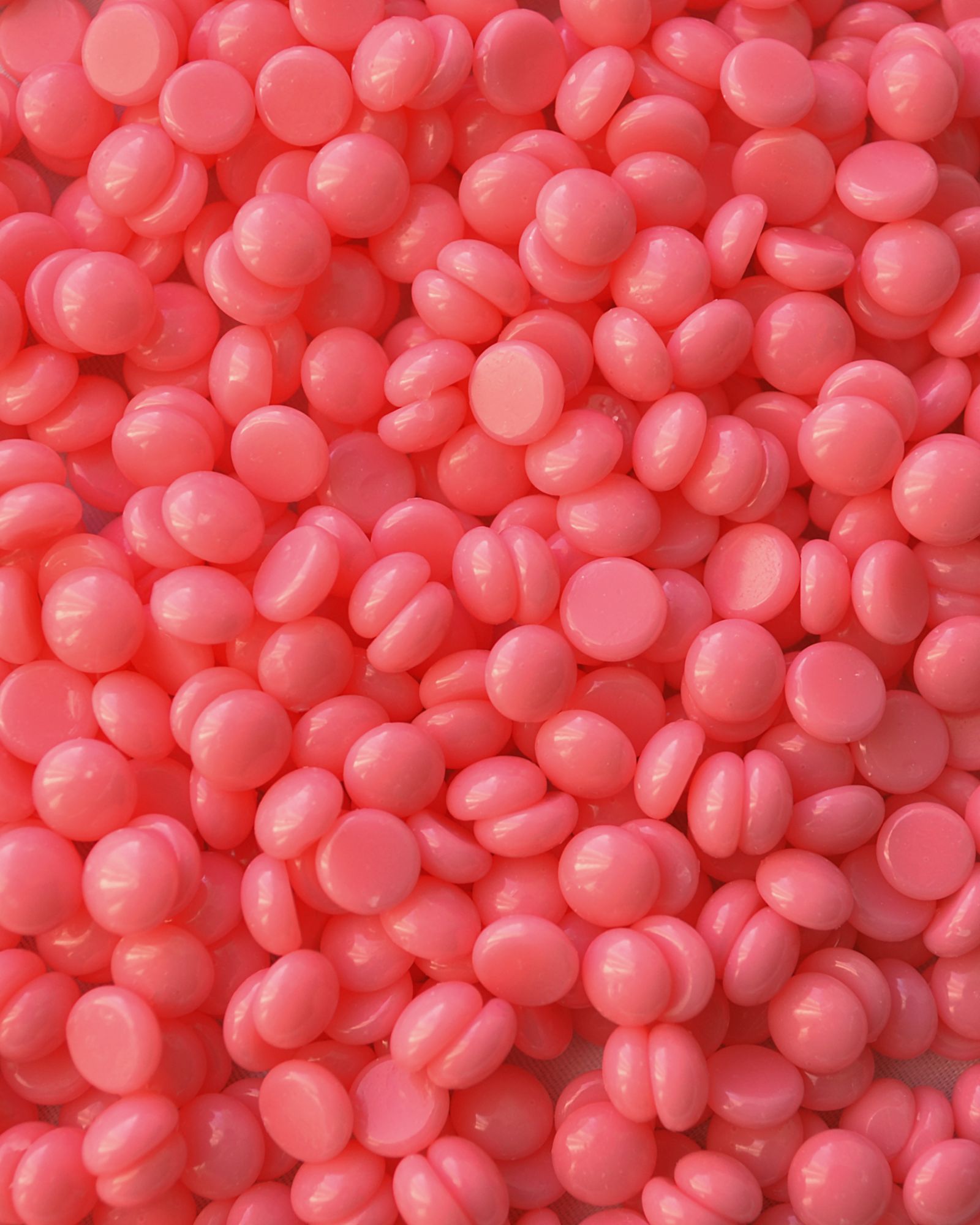 Close-up of pearlescent hard wax beads used for low-temperature film waxing