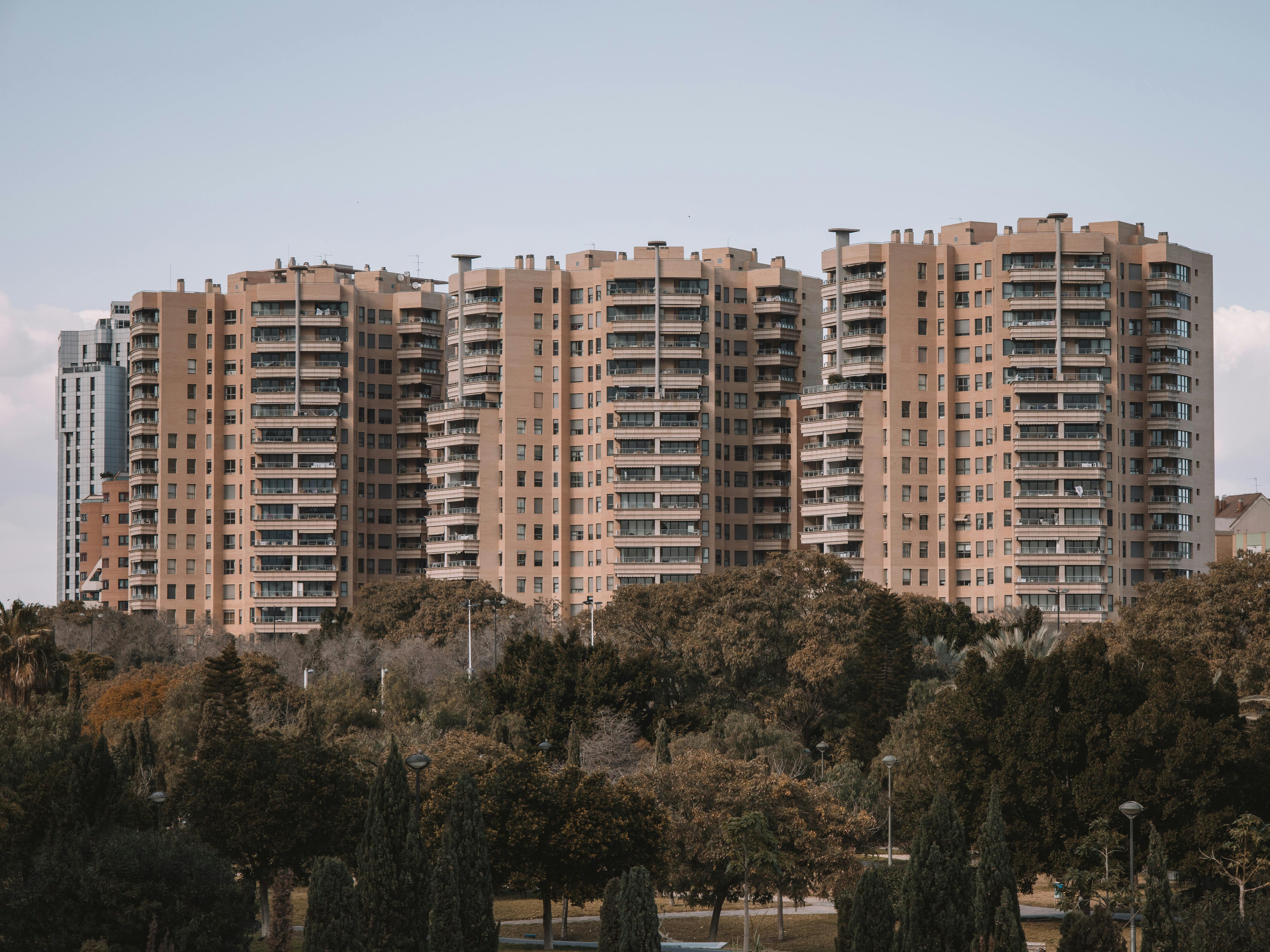 Seventeen‑story apartment buildings in Valencia, Spain, with surrounding greenery under a clear sky.