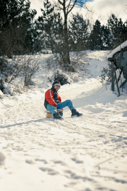 Free Teenager enjoys sliding down a snowy rural hill in Samsun, Türkiye during winter. Stock Photo