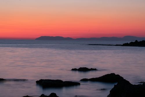 Free A tranquil sunset over Katakolo, Greece, with a calm sea and vibrant sky. Stock Photo