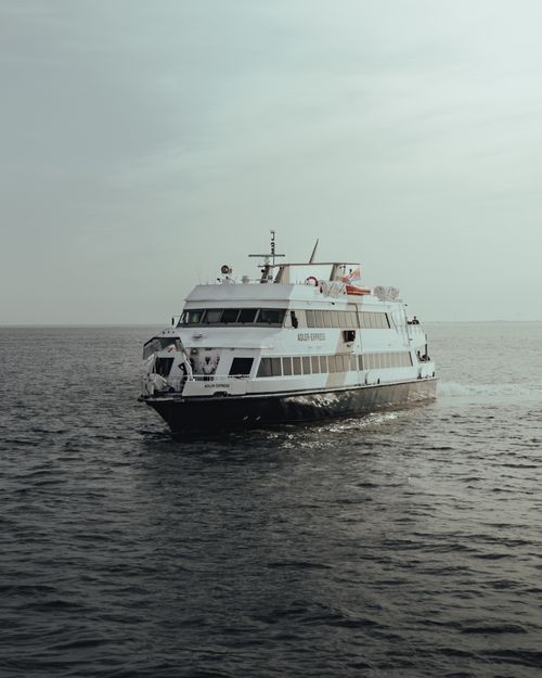 Free A modern passenger ferry cruising through calm open sea under a muted sky. Stock Photo