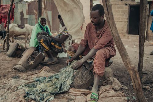 Free A vivid depiction of traditional leather working in a rural village with people and livestock. Stock Photo