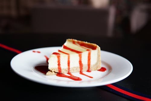 cheesecake, çilek sosu, Gıda içeren Ücretsiz stok fotoğraf