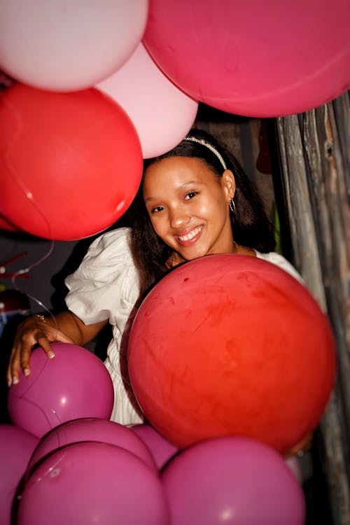 Smiling Girl Standing between Balloons