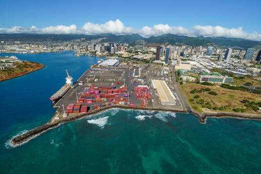 Stunning aerial photograph of Honolulu harbor with colorful shipping containers and city skyline.