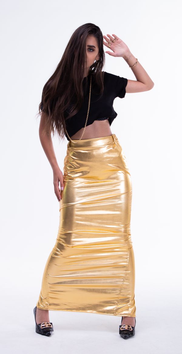 Woman wearing a metallic gold pleated skirt with a black top