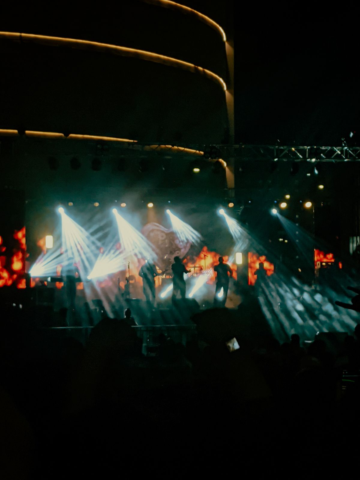 Silhouetted band on stage under dramatic concert lighting