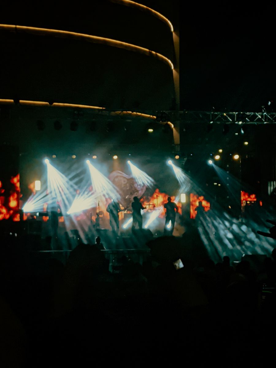 Banda tocando en escenario con iluminación dramática