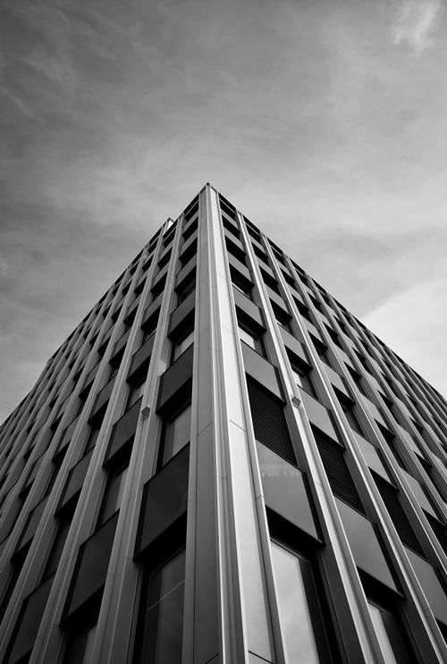 Free Dramatic black and white photo of a skyscraper from a low angle, highlighting modern architecture. Stock Photo