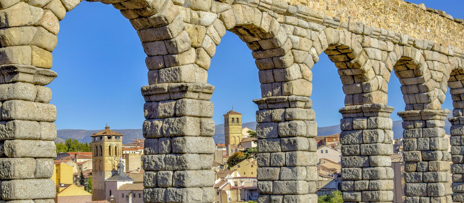 Iconic Roman aqueduct in Segovia with arches overlooking the cityscape.