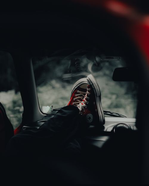 Free Casual scene of a person resting their feet wearing red sneakers inside a car. Perfect for relaxation themes. Stock Photo