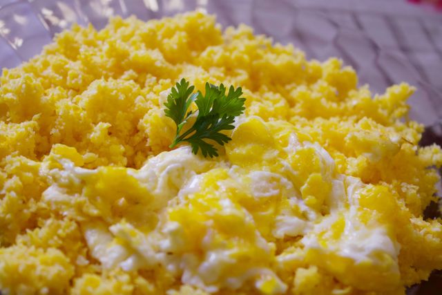 Tasty traditional Brazilian farofa topped with fresh scrambled eggs and parsley.