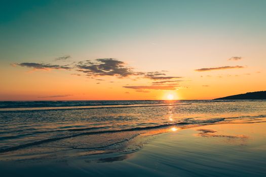 Captivating sunset over the Adriatic Sea with clear skies and a tranquil beach ambiance in Montenegro.