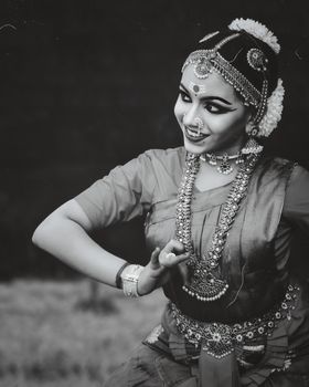 Black and white portrait of a woman in traditional Indian dance attire wearing ornate jewelry.