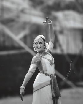 A young woman in traditional attire performs a graceful dance, exuding culture and elegance.