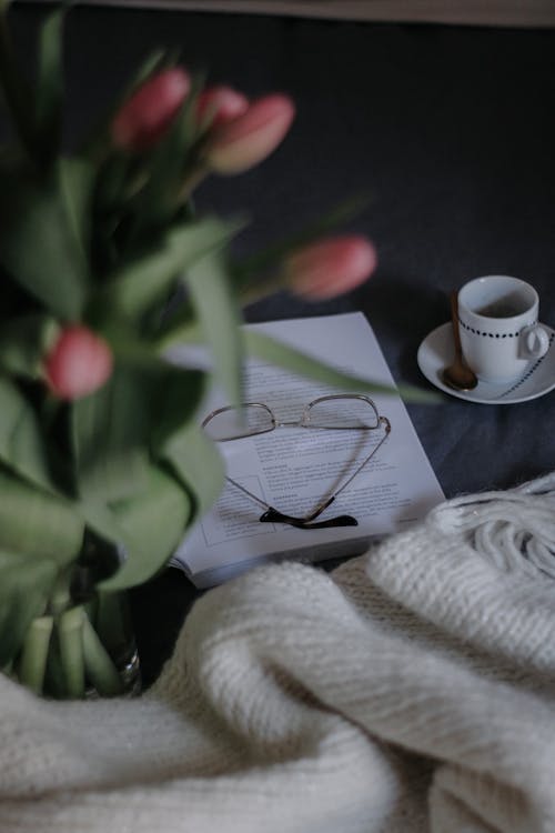 A Bunch of Pink Tulips, Eyeglasses and a Cup on a Table 