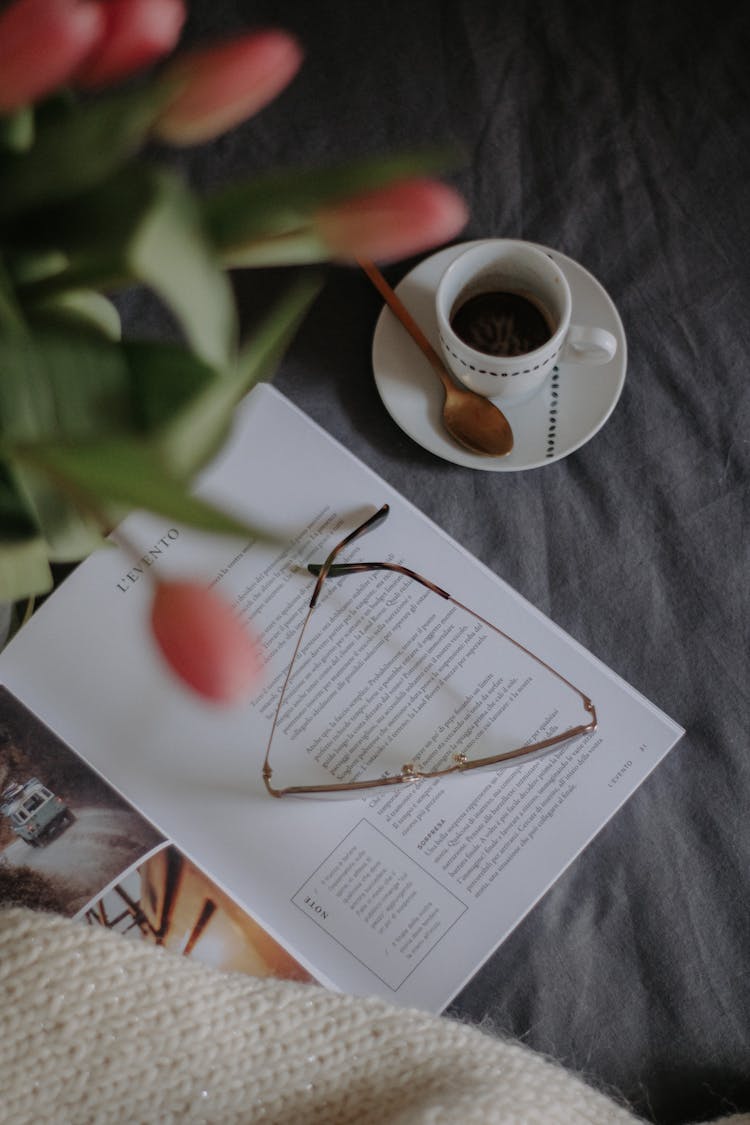 Cup Of Coffee On A Table With Flowers And A Book 