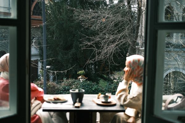 Two people enjoying coffee on a balcony