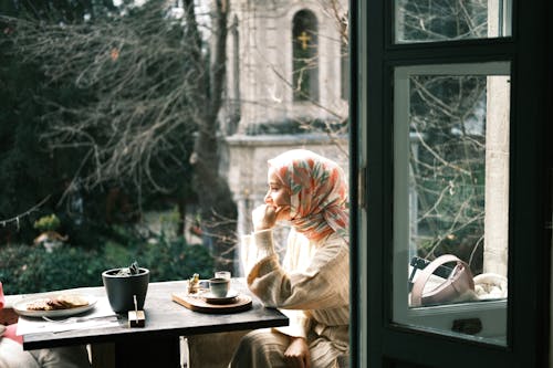 Woman in Hijab Sitting by Table in Cafe