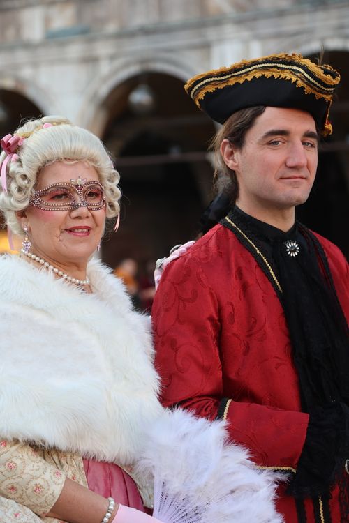 Free A couple in ornate masquerade costumes at a festive outdoor event, showcasing historical elegance. Stock Photo
