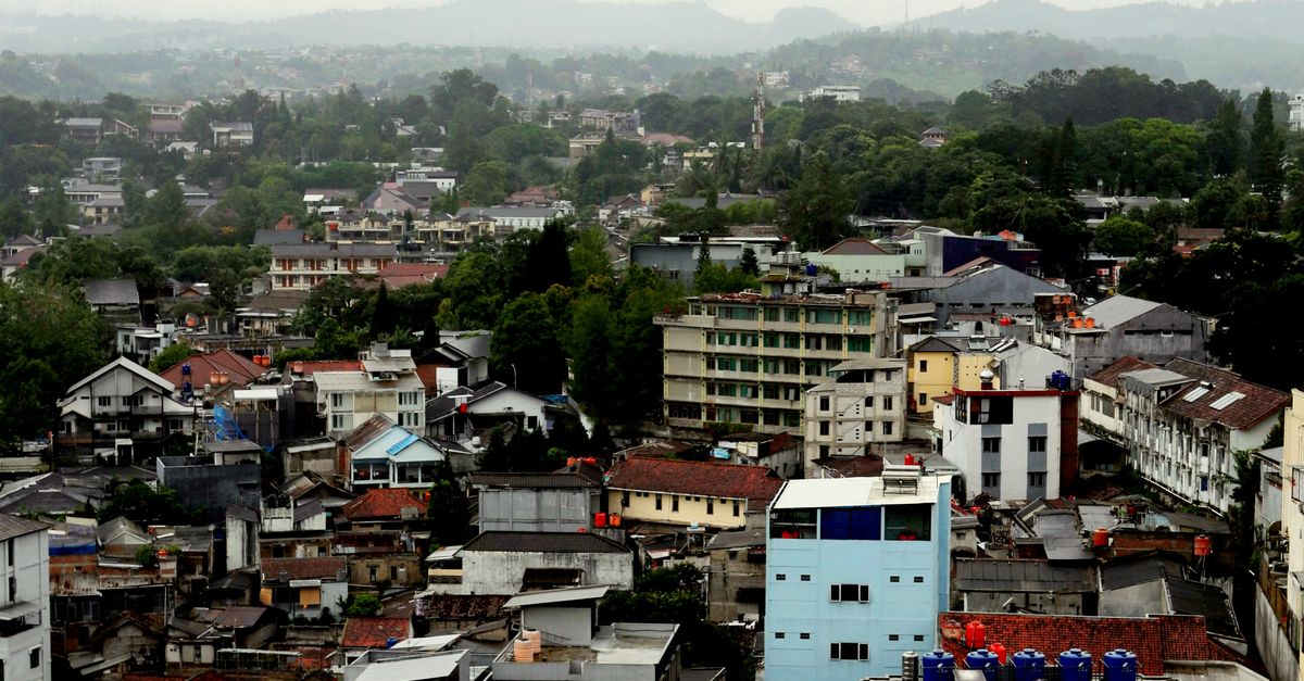 Explore an aerial view of Bandung, Indonesia, capturing buildings under an overcast sky.