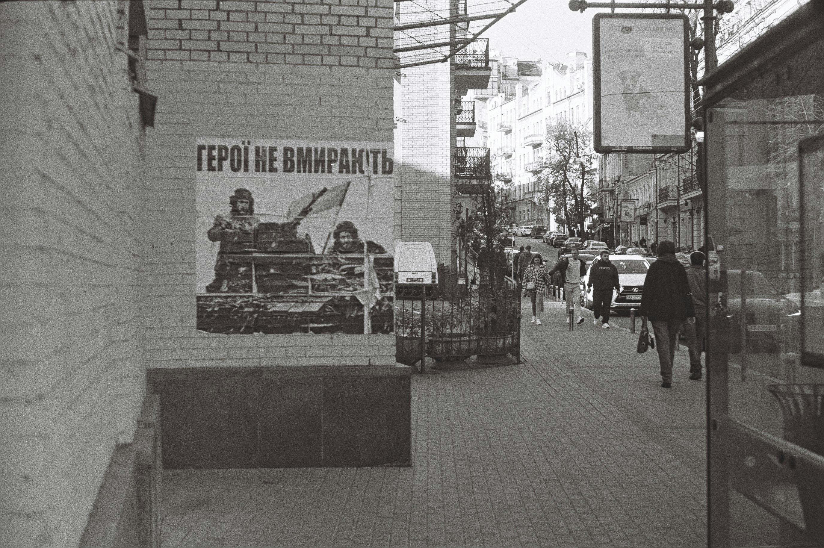 無料 キエフの白黒の都市風景。歩道に軍のポスターが貼られている。 写真素材