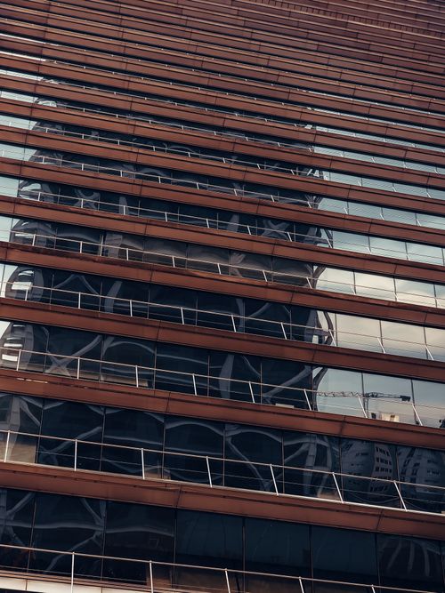 Free Low angle view of a modern skyscraper facade reflecting another building in Barcelona, Spain. Stock Photo
