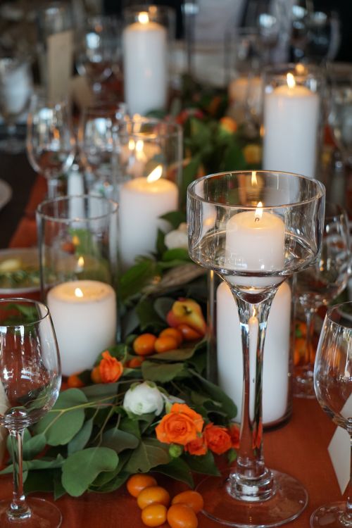 Free A warm and festive table decoration featuring candles and floral elements, perfect for celebrations. Stock Photo