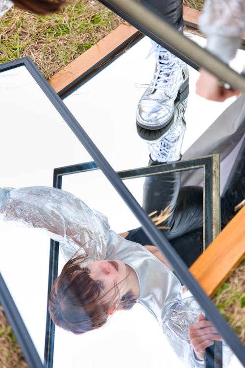 Pretty Brunette Reflecting in Mirrors Lying on the Ground