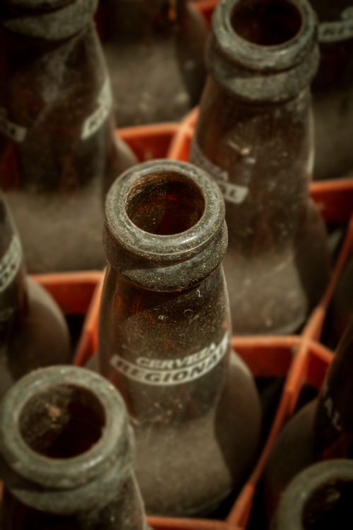 Free Close-up of dusty empty beer bottles in a crate, showing vintage labels and texture. Stock Photo