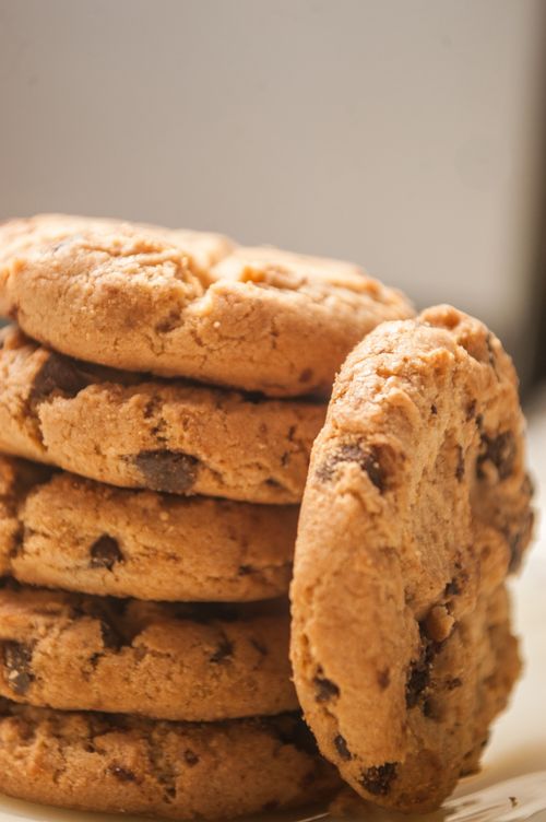 Free Close-up shot of stacked chocolate chip cookies with a warm, inviting tone. Stock Photo