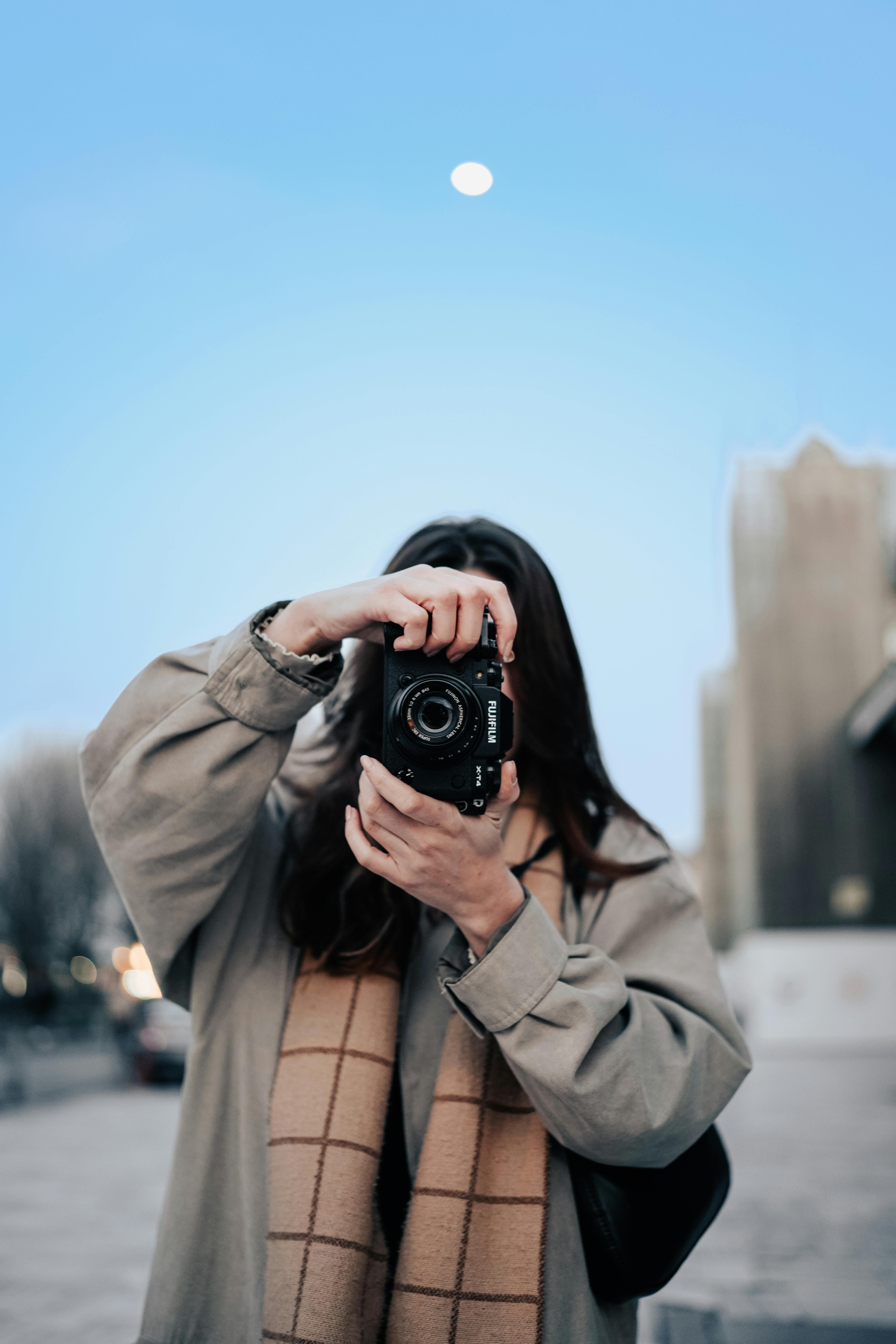 fashionable woman taking a picture with a camera