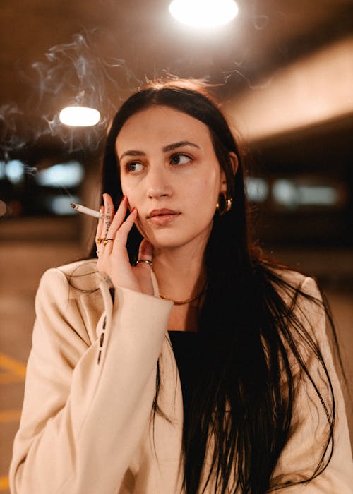 Young Woman Smoking a Cigarette in a Parking Garage