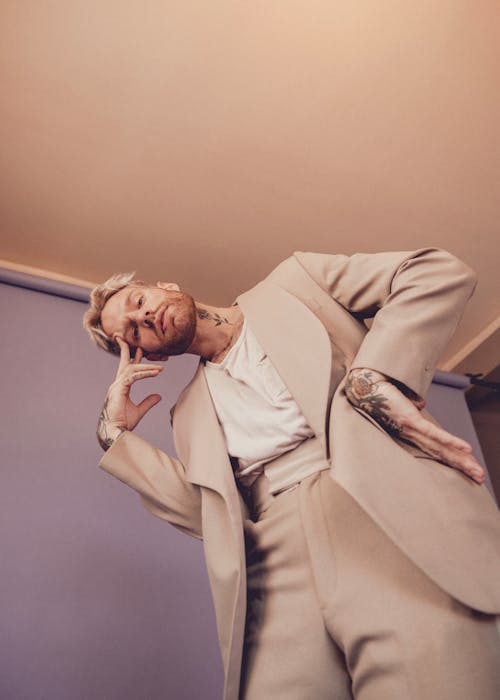 Low Angle Shot of a Man with Tattoos in a Suit 