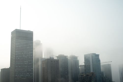 Free Silhouetted skyscrapers shrouded in fog create a mystic urban skyline view. Stock Photo