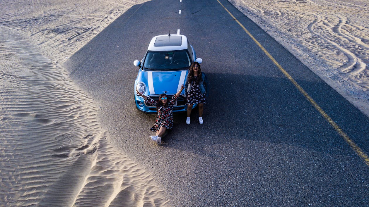 Two Women in Front of Blue Vehicle