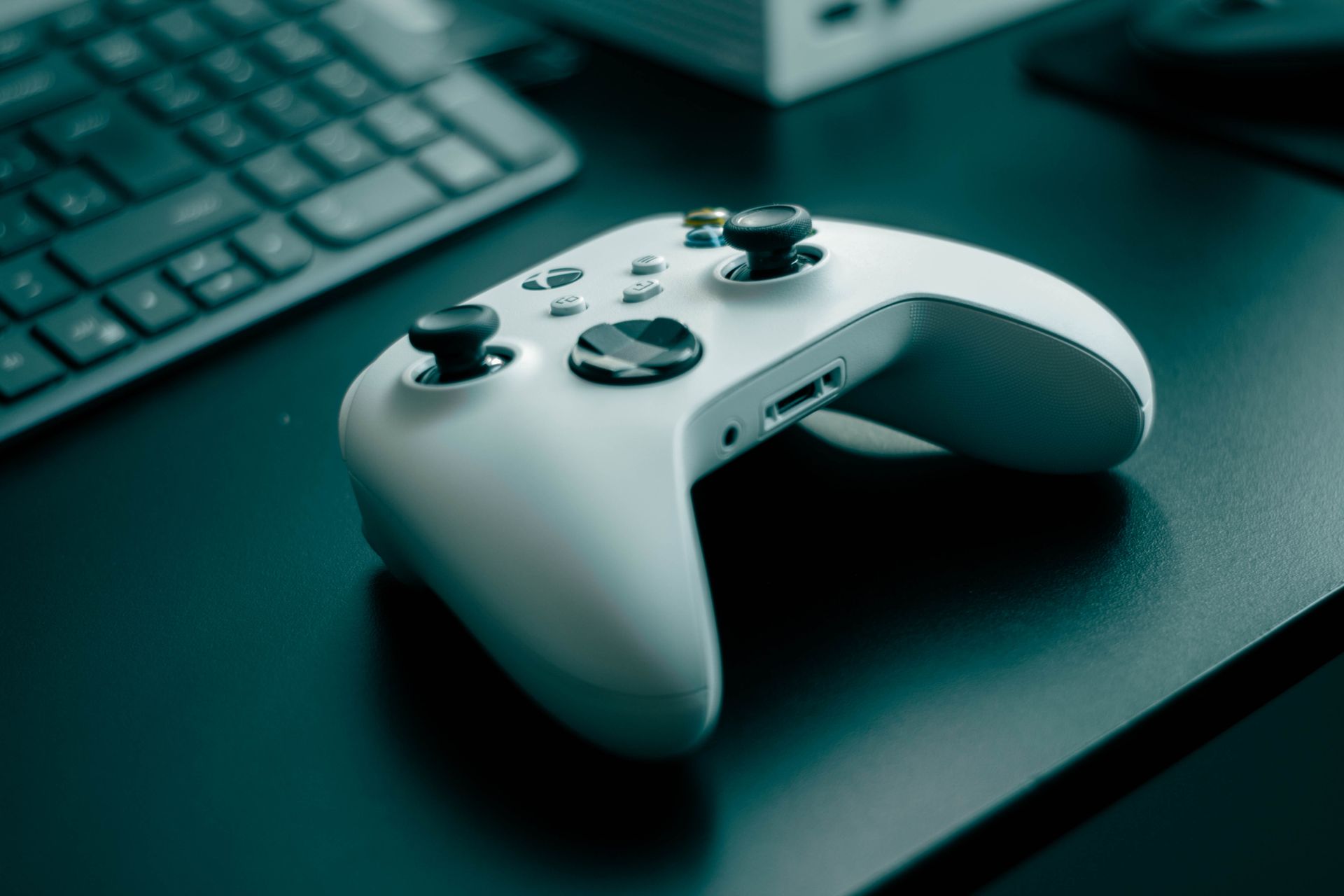 Mando y consola de videojuegos sobre un escritorio