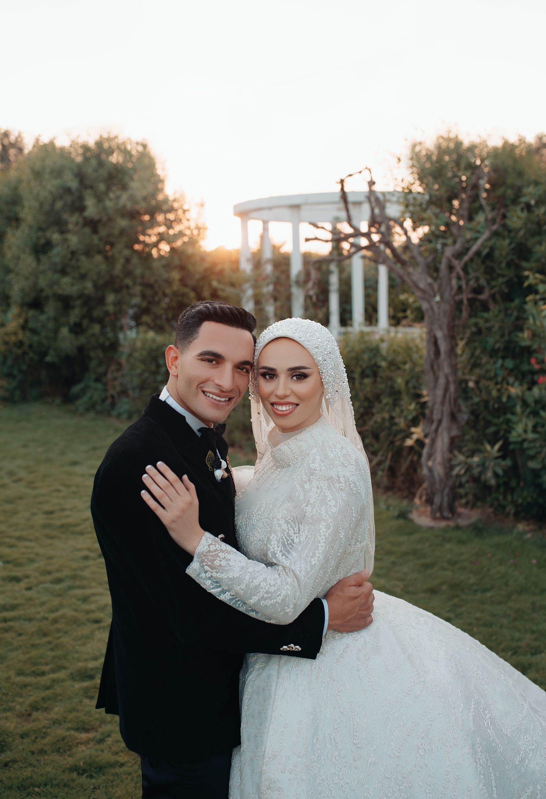 Arab bride and groom in formal wedding attire posing in a garden in Cairo