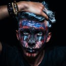 这幅特写肖像令人惊叹，描绘了一位面部彩绘鲜艳、表情激烈的男子，非常适合艺术主题